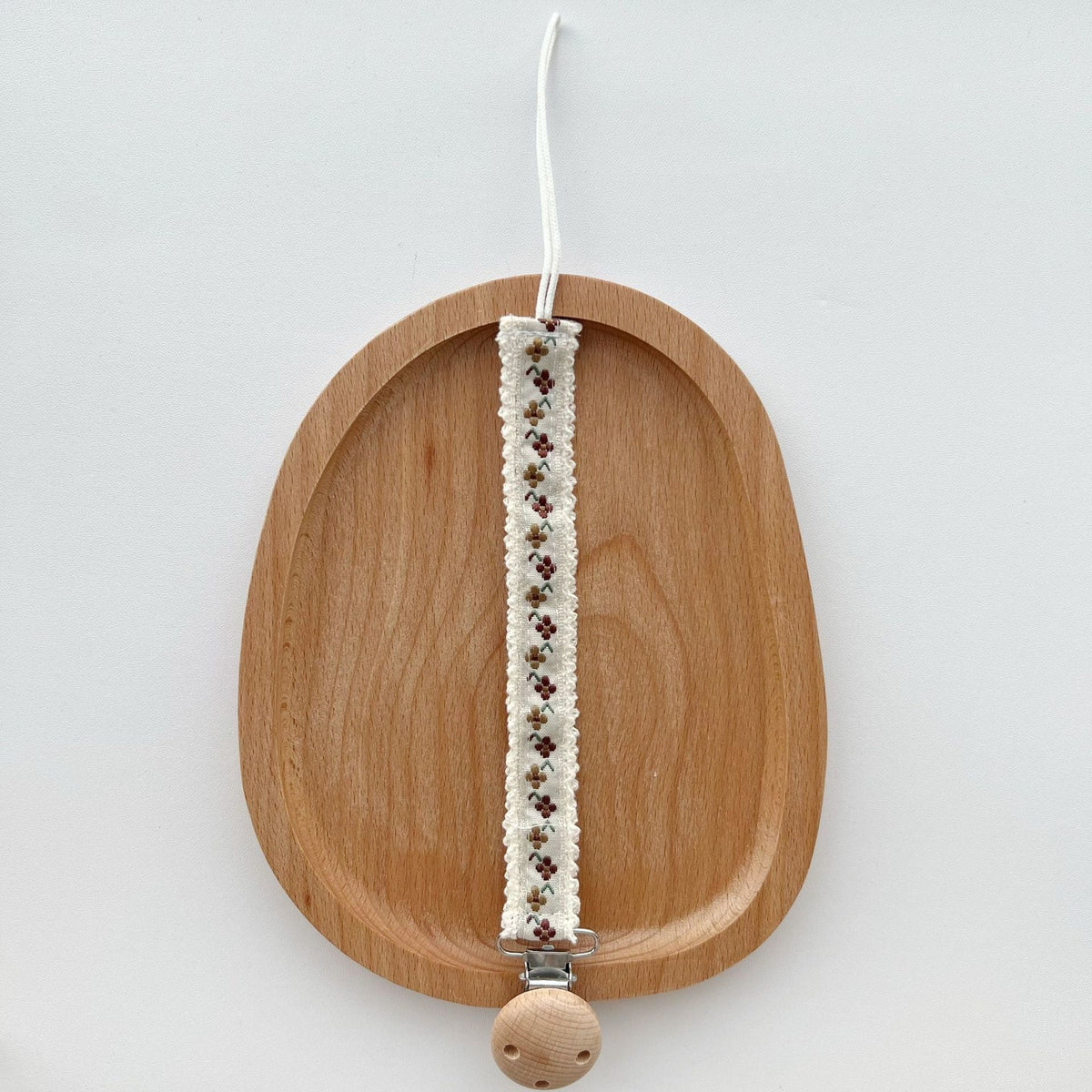 Floral Ribbon Dummy Clip, Lace Edge Soother Holder with Beech Wood Clip, 28.5 cm, 7 Designs, styled on a shelf
