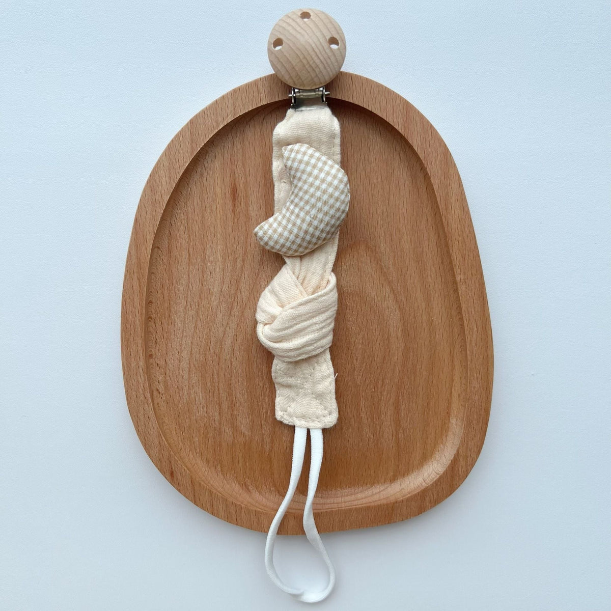 Cotton Dummy Clip, Knitted Soother Holder with Plush Motif & Beech Wood Clip, 27 cm, 8 Designs, shown on a bed