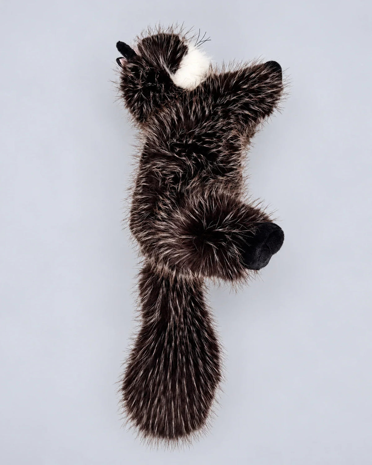 Realistic black cat plush toy, lying down, back view