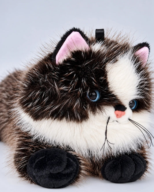 Realistic black cat plush toy, lying down, close-up