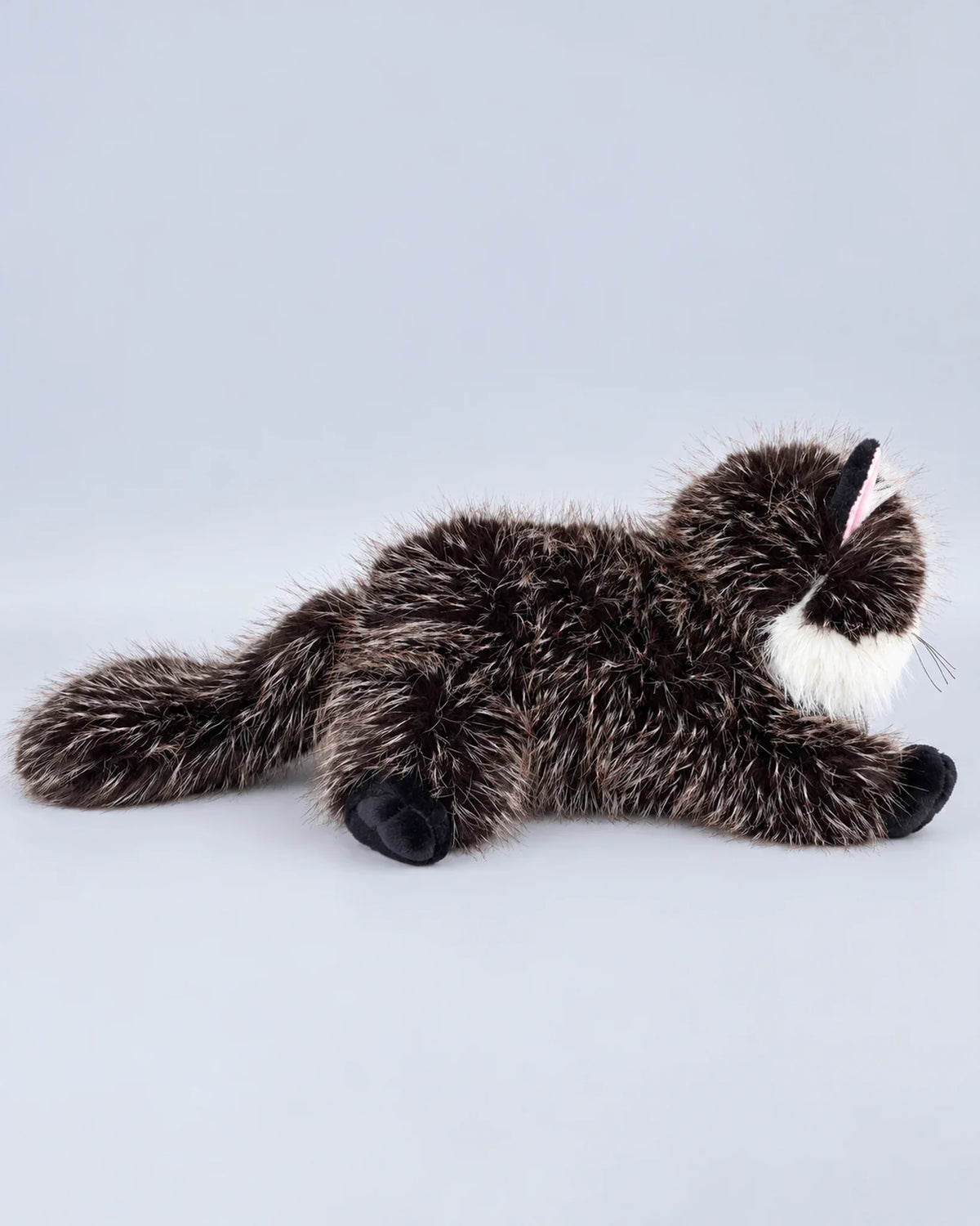 Realistic black cat plush toy, lying down, back view