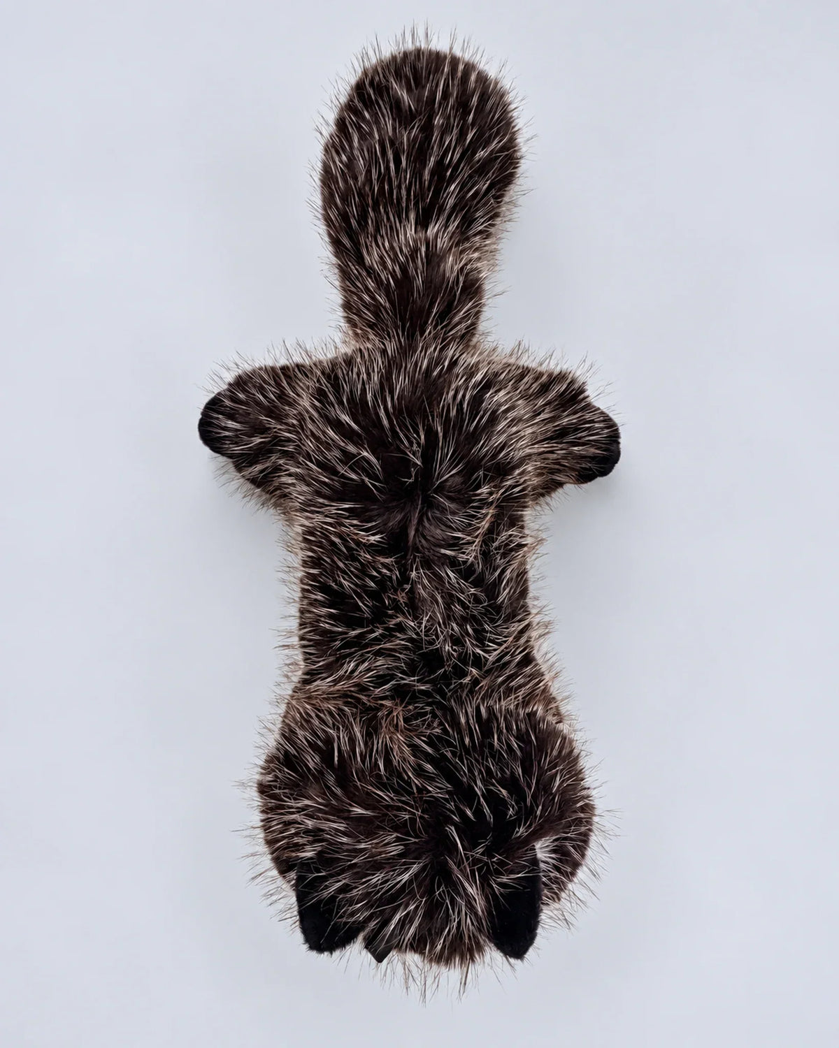Realistic black cat plush toy, lying down, top view