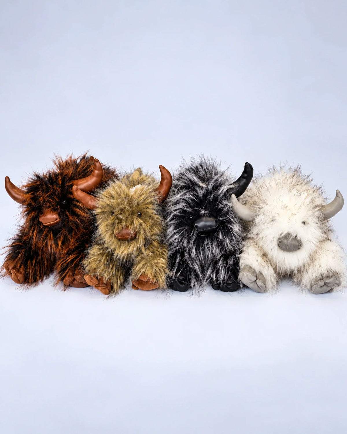 Four Highland cow plush toys in Rustic Brown, Golden Tan, Smoky Black and Frost White